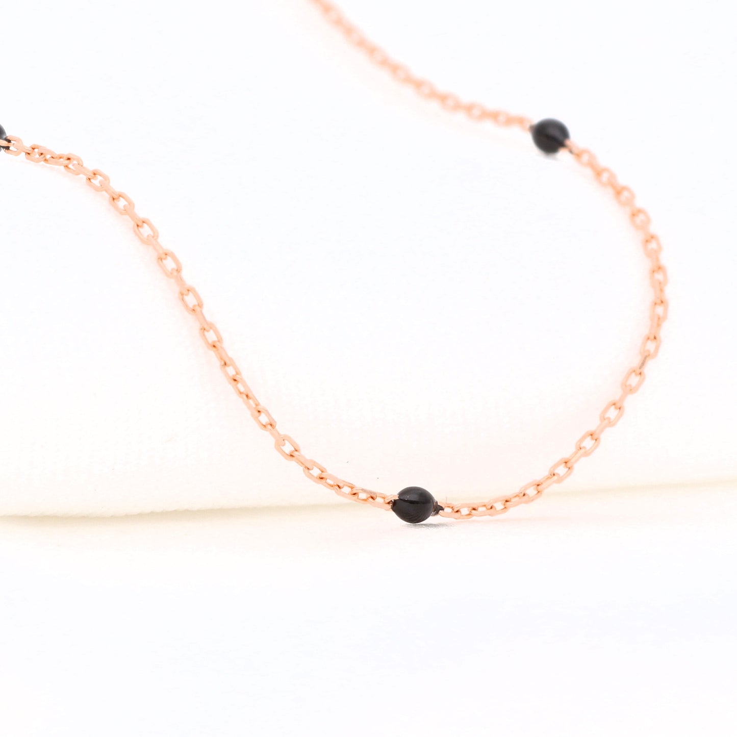 Auksinė grandinėlė su juodomis detalėmis