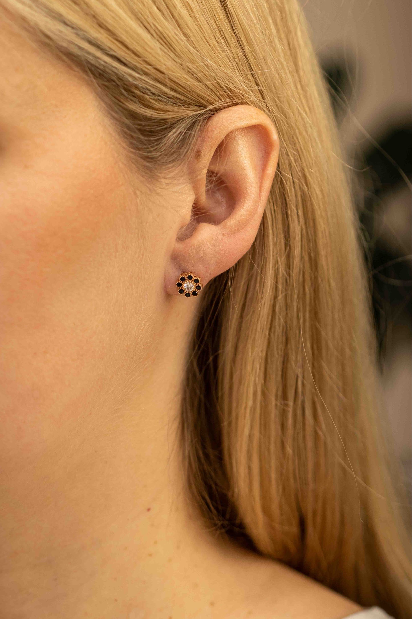 Gėlytės formos auksiniai auskarai su cirkoniais ant modelio – realus vaizdas