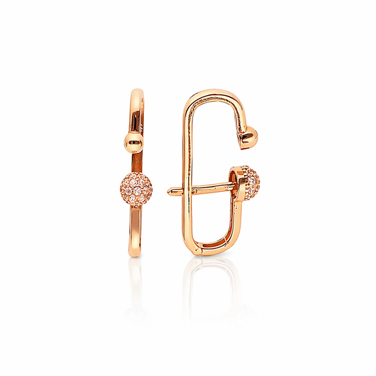 Modernūs rožinio aukso auskarai su cirkoniais ant balto fono